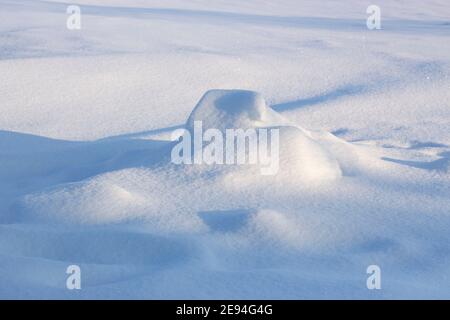 Snowdrift and shadow. Snowy background, winter snow texture on a sunny evening. Stock Photo