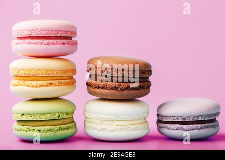 Colorful French macaroni cookies are arranged in a pyramid on the background. Top view, free space Stock Photo