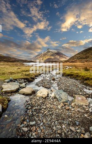 Stepping stones across a stream leading to Llyn Idwal in Cwm Idwal Nature Reserve with Pen yr Ole Wen mountain in the background, Snowdonia, Wales Stock Photo
