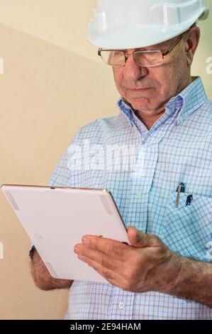 Senior Hispanic social worker taking notes on the tablet Stock Photo
