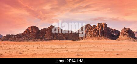 Planet Mars like landscape - Photo of Wadi Rum desert in Jordan with red pink sky above, this location was used as set for many science fiction movies Stock Photo