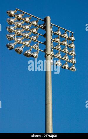 Floodlights against a blue sky at a sport stadium in London. Stock Photo