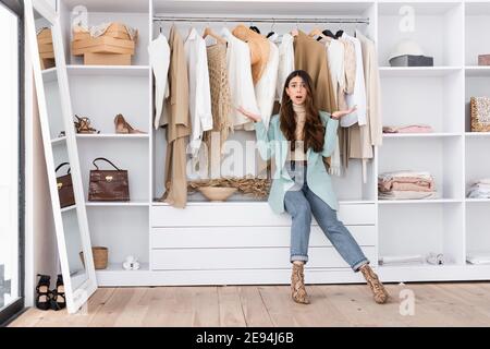 Worried woman pointing with hands in wardrobe Stock Photo