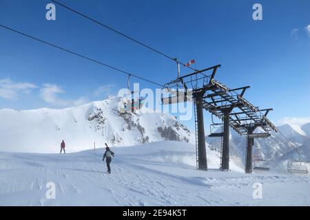 BAD HOFGASTEIN, AUSTRIA - MARCH 9, 2016: People ride a ski lift in Bad Hofgastein. It is part of Ski Amade, one of largest ski regions in Europe with Stock Photo