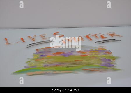 Oil painting, in various colors horizontally on white glass, white background with the inscription Lives Matter, orange text, Brazil, South America Stock Photo