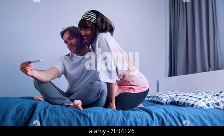 Excited young couple waiting for results of pregnancy test. Positive test. Multiracial couple expecting baby. High quality photo Stock Photo