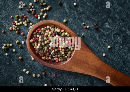 Mixed of peppercorns in a wooden spoon, top view, close up Stock Photo