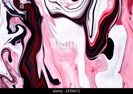 Macro shot of a mix of acrylic paint and oil on a marbled paper background. Stock Photo