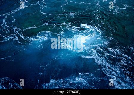 Dark blue deep sea background with rippled water and swirl of sea foam on the surface Stock Photo