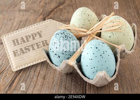 Happy Easter label and eggs close-up against wooden background Stock Photo
