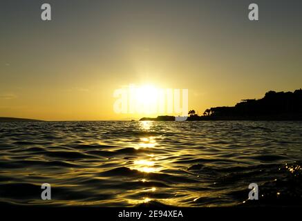 Wavy and shiny sea water surface at beautiful sunset by the seaside Stock Photo