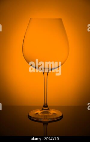 Vine glass on reflecting surface over background, studio advertising shot, copy space Stock Photo