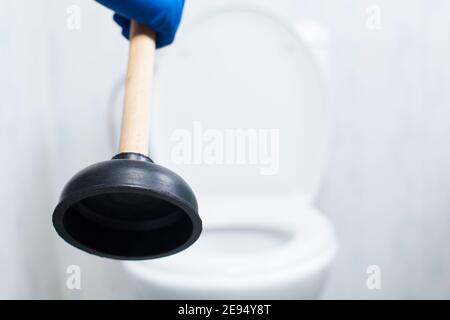 Cleaning clogg in toilet with ventuz, close up. Plumbing service with plunger close-up. Stock Photo