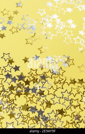 Gold and silver star dust sparkle on yellow. Chaotic cosmic background with gold star elements flying. Gold glitter dust confetti, magic shining sparkles scatter. Starry festive decor. Stock Photo