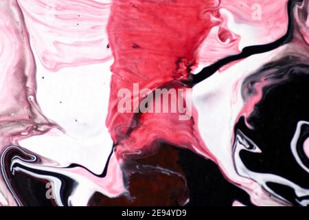 Macro shot of a mix of acrylic paint and oil on a marbled paper background. Stock Photo