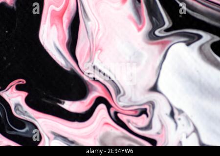 Macro shot of a mix of acrylic paint and oil on a marbled paper background. Stock Photo