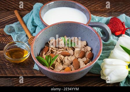 Spelt flakes with milk on breakfast. Light breakfast on Valentine's day with tulips and heart Stock Photo