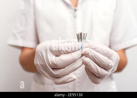 Stock photo of faceless worker in physiotherapy clinic holding acupuncture needles. Stock Photo