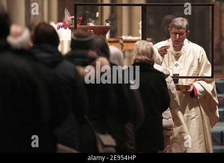 Cologne, Germany. 02nd Feb, 2021. Cardinal Rainer Maria Woelki (r), Archbishop of Cologne, celebrates Holy Communion with the faithful during a service in the cathedral. Credit: Oliver Berg/dpa/Alamy Live News Stock Photo