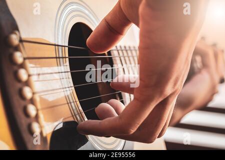 Close up a man's hands playing acoustic guitar. Playing acoustic guitar at a recording studio. Stock Photo