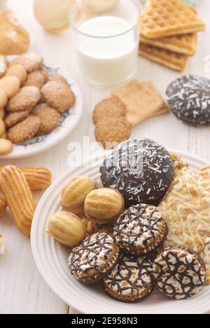 Still life with various fresh baked sweet pastry on white wooden table Stock Photo
