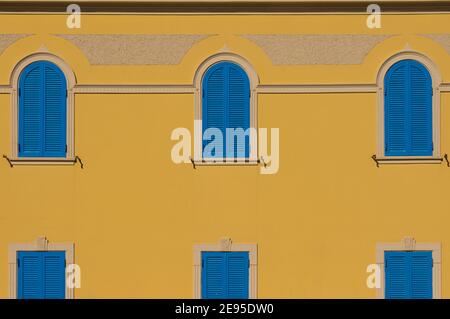 fasade with yellow wall and blue windows for backgrounds Stock Photo