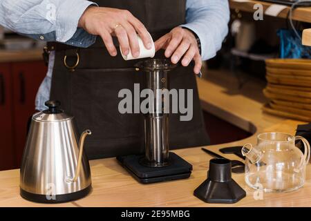 https://l450v.alamy.com/450v/2e95mbg/aeropress-coffee-barista-spread-ground-coffee-to-pot-alternative-coffee-brewing-method-handsome-bearded-barista-makes-tasty-scandinavian-coffee-2e95mbg.jpg