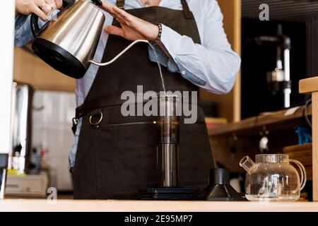 Aeropress coffee: barista press to device and coffee drops pours trought  aeropress to pot. Alternative coffee brewing method. Vertical photo  handsome Stock Photo - Alamy