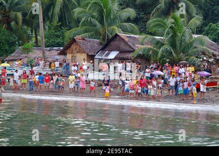 Townspeople from the small village of Himbangan greet U.S. Navy personnel from the shoreline, as seen from an 11 meter Rigid Hull Inflatable Boat deployed from the amphibious dock landing ship USS Harpers Ferry on February 20, 2006. Teams were deployed to conduct beach landing survey of the area. US Navy ships are providing humanitarian assistance to victims in the Saint Bernard Municipality, where the town of Guinsahugon located in the southern part of the island was completely devastated during a Feb. 17 landslide. Photo USN Via ABACAPRESS.COM Stock Photo