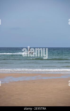 Man riding a jet ski in the sea off the coast of Cornwall, England, UK Stock Photo
