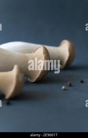 Eringi mushrooms in plastic packaging on a gray background. Pleurotus eringi. Vegetarian food concept. Close-up. Copy space. Stock Photo