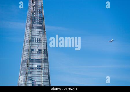 Low flying passenger plane close to the Shard on its final approach to landing at London City Airport, England, UK
