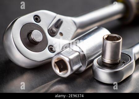 Chrome ratchet wrenches on the workbench. Tools used for mechanical repairs. Workshop workplace. Stock Photo