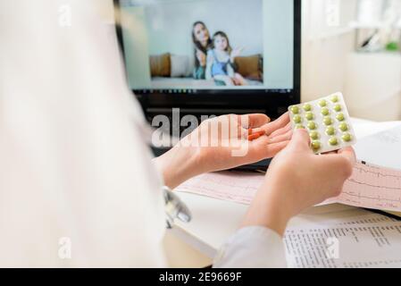 Close-up Of A Woman Video Conferencing With Female Doctor On Laptop.online pediatrician consultation. Mom and baby in her arms talking via video.offer Stock Photo