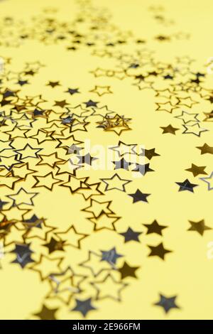 Gold and silver star dust sparkle on yellow. Chaotic cosmic background with gold star elements flying. Gold glitter dust confetti, magic shining sparkles scatter. Starry festive decor. Stock Photo