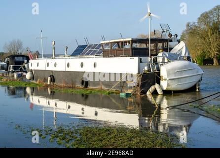 Cookham, Berkshire, UK. 2nd February, 2021. A narrowboat becomes level with land as the River Thames overflows onto adjacent fields. A Flood Alert is in place in Cookham as the River Thames has burst it's banks. The Environment Agency were on hand today pumping out drains. Credit: Maureen McLean/Alamy Live News Stock Photo