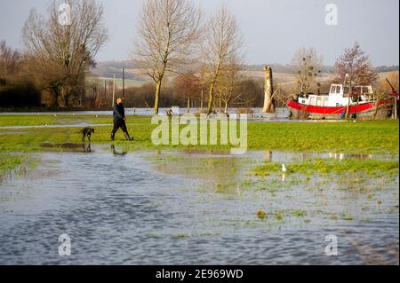 Cookham, Berkshire, UK. 2nd February, 2021. A man walks across flooded fields next to the River Thames. A Flood Alert is in place in Cookham as the River Thames has burst it's banks.  The Environment Agency were on hand today pumping out drains. Credit: Maureen McLean/Alamy Live News Stock Photo