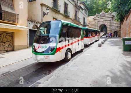 Granada City Tour road train at Puerta de las Granadas (Gate of Pomegranates), the triumphal arch entrance to Alhambra y Generalife, Granada, Spain Stock Photo