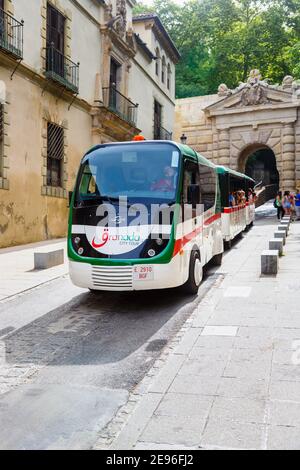 Granada City Tour road train at Puerta de las Granadas (Gate of Pomegranates), the triumphal arch entrance to Alhambra y Generalife, Granada, Spain Stock Photo