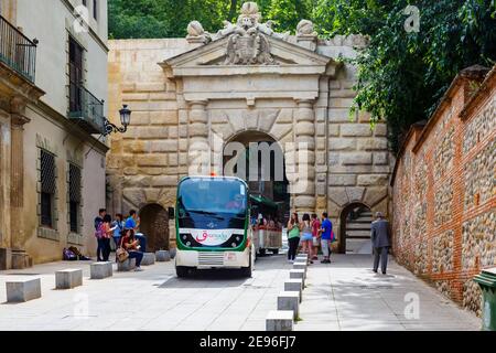 Granada City Tour road train at Puerta de las Granadas (Gate of Pomegranates), the triumphal arch entrance to Alhambra y Generalife, Granada, Spain Stock Photo