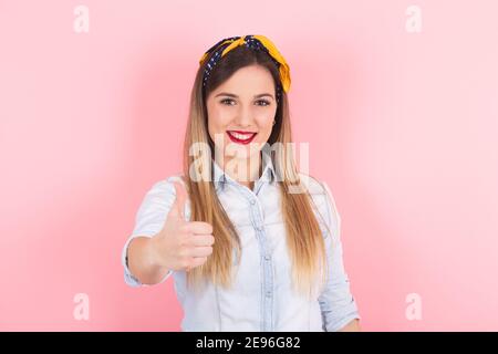 a young blonde woman shows her thumbs up. Positive concept Stock Photo
