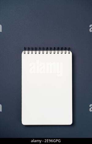 School notebook on a paper black background, spiral notepad and craft cardboard pen Stock Photo