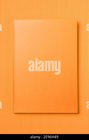 Orange Leather notebook on paper orange background, notepad mock up, top view shot Stock Photo
