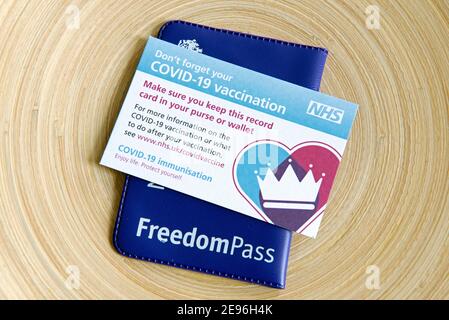 Covid-19 Vaccination or vaccine Card with Freedom Pass.  The elderly will soon be able to travel safely on public transport after their second jab. Fr Stock Photo