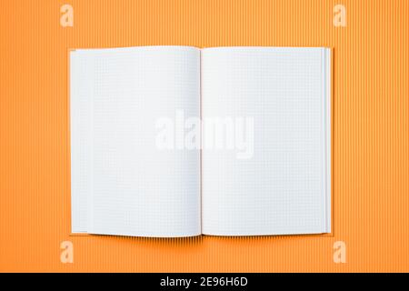 School notebook on a paper orange background, opened notepad and craft cardboard pen Stock Photo