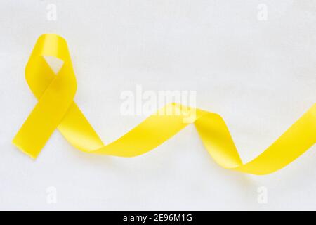 Yellow ribbon on white isolated background, copy space. Bone cancer, Sarcoma Awareness, childhood cancer awareness, cholangiocarcinoma, gallbladder ca Stock Photo