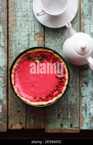 Minimalist style tea and dessert. Homemade lingonberry pie and white teaware on old shabby blue background top view copyspace Stock Photo
