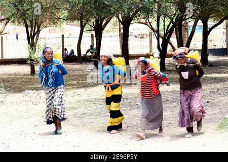 Tigray women carrying water jerrycans on their backs. Stock Photo