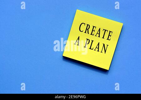 Create a plan text on yellow sticky note with blue background Stock Photo