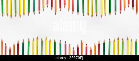 Banner of pencils different colors fro red to green o the top and bottom flat lay top view on white background with copy space.  Education banner back Stock Photo
